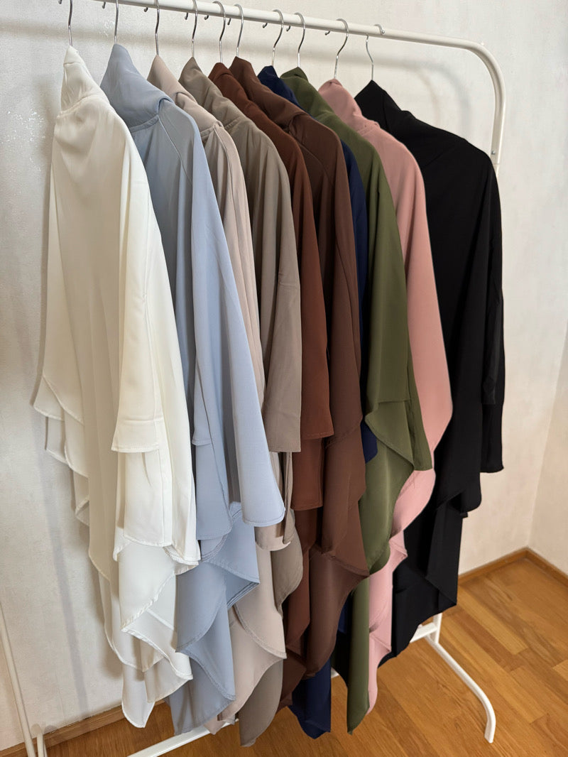 2-kerroksiset khimarit niqab-nauhoilla – hijab musliminaisille kaikissa väreissä: valkoinen, vaaleanharmaa, beige, taupe, vaaleanruskea, tummanruskea, tummansininen, khaki, vaaleanpunainen ja musta, esillä vaaterekissä.